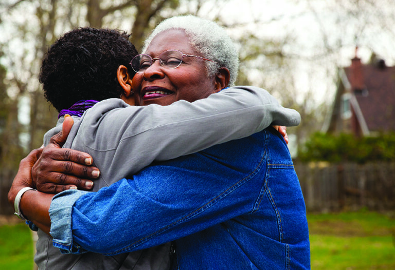African American senior hugging her daughter