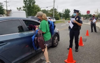 Oaks staff member hands out backpacks