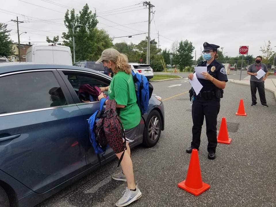 Oaks staff member hands out backpacks
