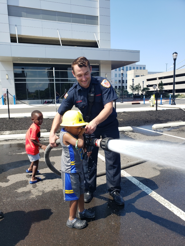 Touch A Truck 5 Child with firehose and fireman