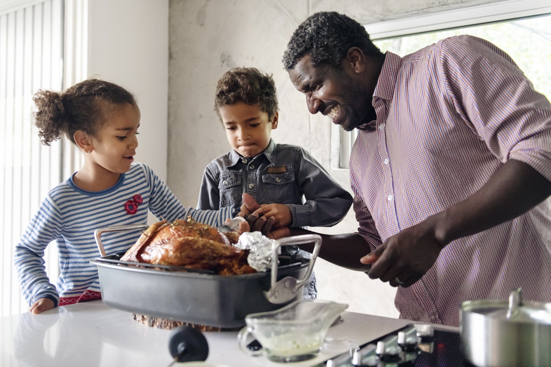 Fathers preparing thanksgiving turkey Family cooking Thanksgiving dinner