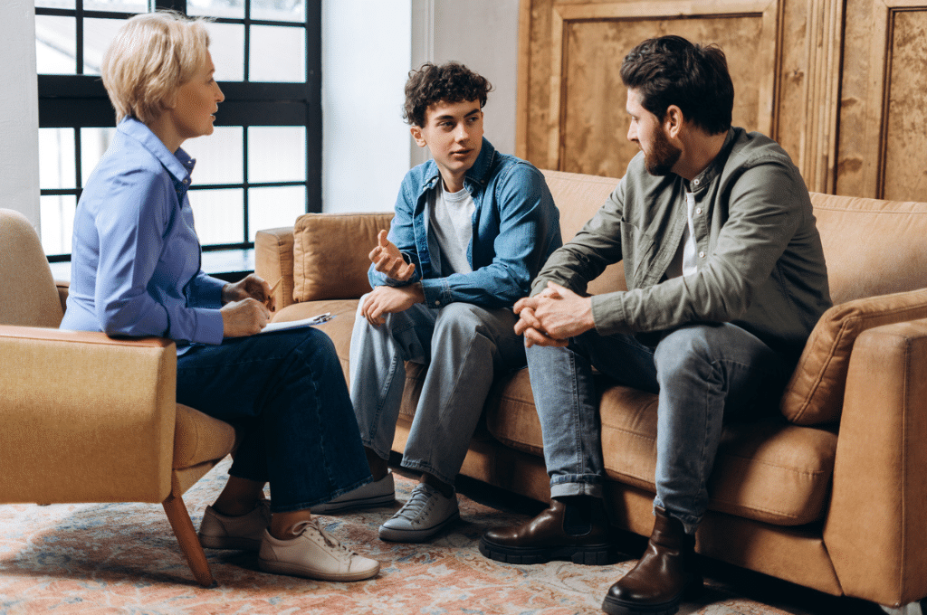 Father and son talking to therapist