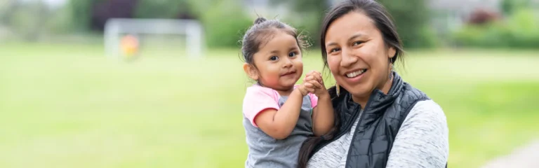 Smiling Mother Holding a Toddler