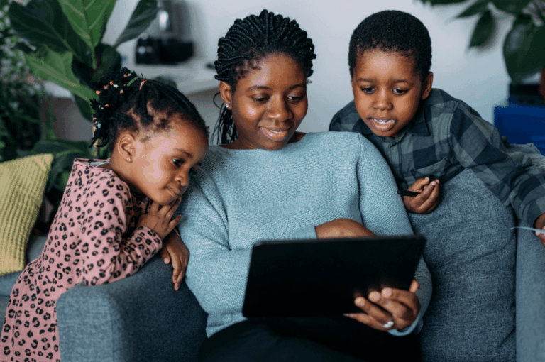 Mother looking at computer with children
