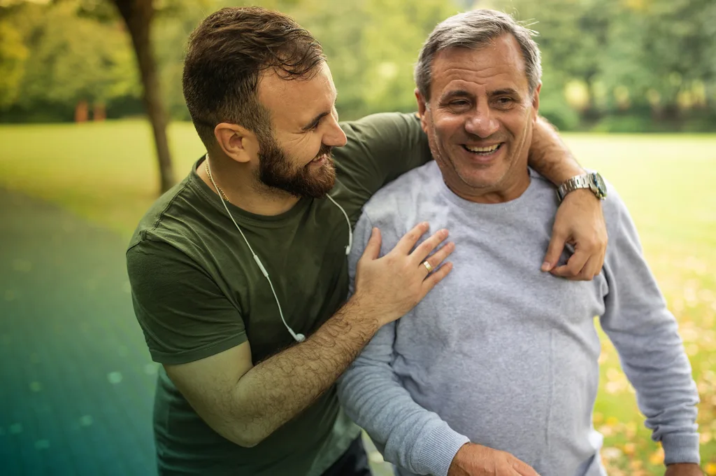 Father and Adult Son smiling in park